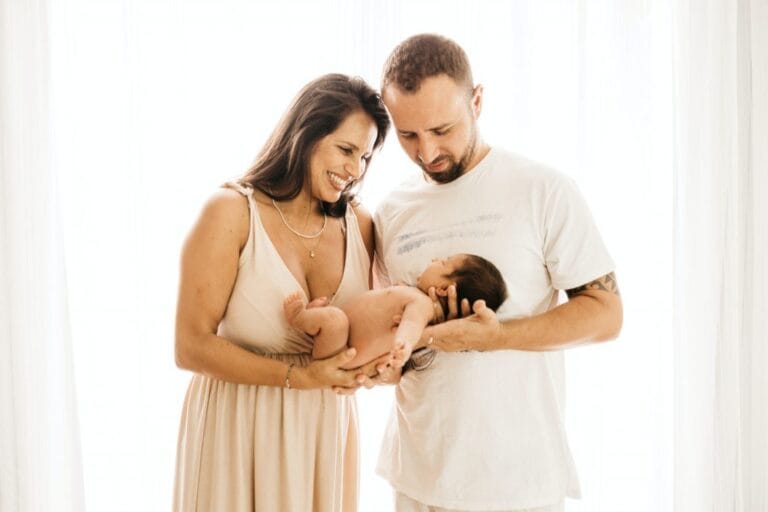 Photo montrant un jeune couple heureux, tenant un nourrisson.